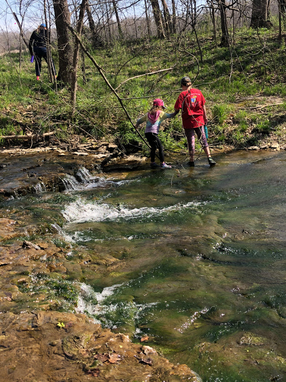 Family crossing a shallow creek